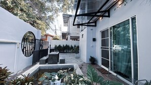 A modern building with a courtyard, a small pond, and potted plants.