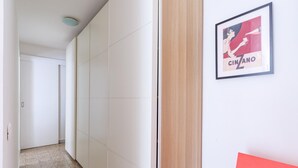 A hallway with white walls and a wooden door. A framed poster with the text "CINZANO" is visible on the wall. - Quite Shelter in Naples (Naples)