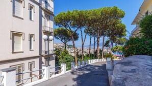A narrow street with a row of trees and buildings on one side. - Quite Shelter in Naples (Naples)