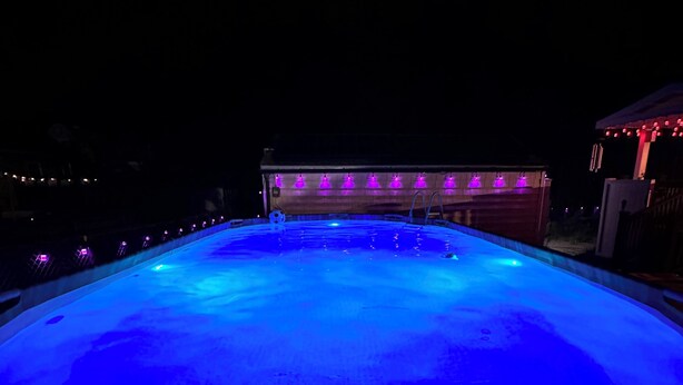 A swimming pool at night with blue lighting.