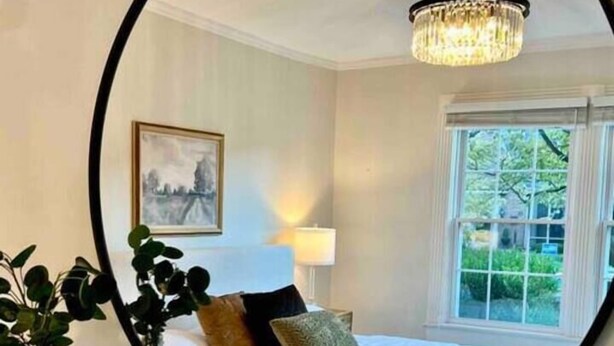 A bedroom with a bed, a chandelier, a window, and a mirror. - Blue Moon Cottage: Historic Owensboro Home w/ Large Pool, Music Room, Location! (Owensboro)