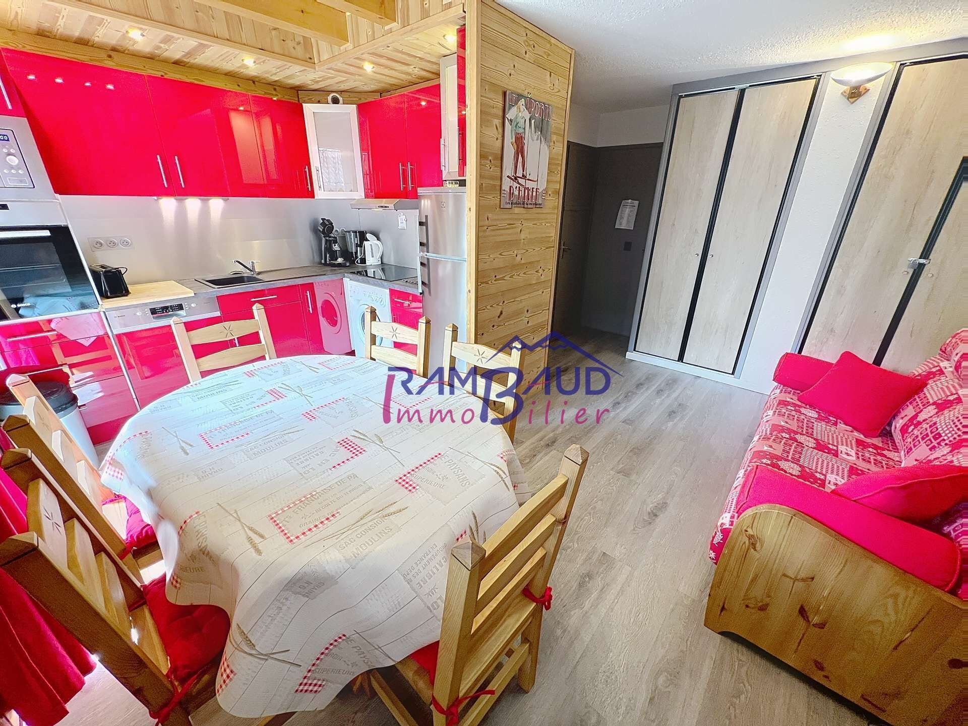 A compact living space with a kitchen, dining area, and a small bedroom.