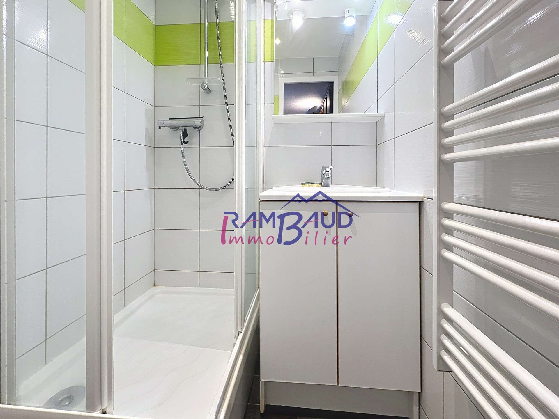 Ein Badezimmer mit Dusche, Waschbecken und Spiegel.
