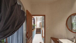 Een badkamer met een houten wastafelmeubel, een wastafel en een spiegel.