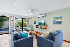 A modern living room with a sofa set, a coffee table, and a TV.