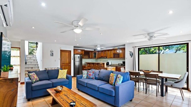 A spacious living room with two sofas, a coffee table, and a dining area with a table and chairs. - Inviting Home with Colorful Decor and Private Backyard Oasis with a Swimming Pool & Shaded Terrace (Santa Cruz)