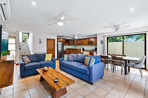 A spacious living room with two sofas, a coffee table, and a dining area with a table and chairs.