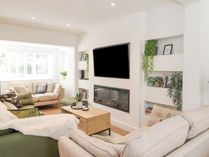 A modern living room with a sofa, coffee table, and fireplace.