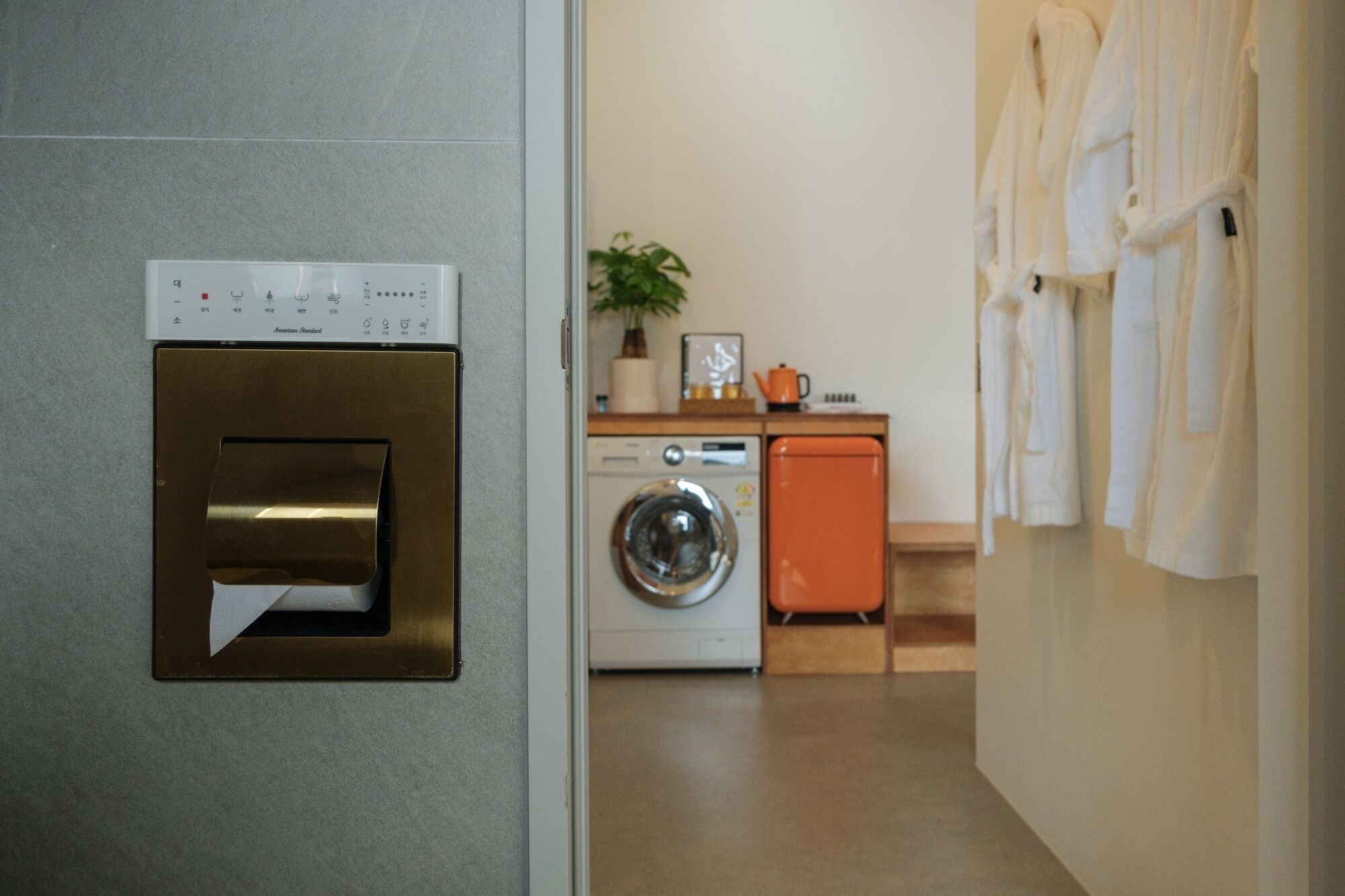 A laundry area with a washing machine, a dryer, and a wall-mounted dryer.