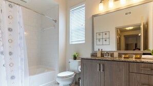 A modern bathroom with a shower, toilet, and vanity.