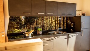 A modern kitchen with a large window, stainless steel appliances, and a built-in herb garden. - Holiday Apartment "Kieserhof Wald" with Mountain View, Private Terrace & Wi-Fi (Terenten)