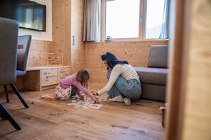 Un intérieur en bois avec un canapé, un téléviseur et une fenêtre avec des rideaux.