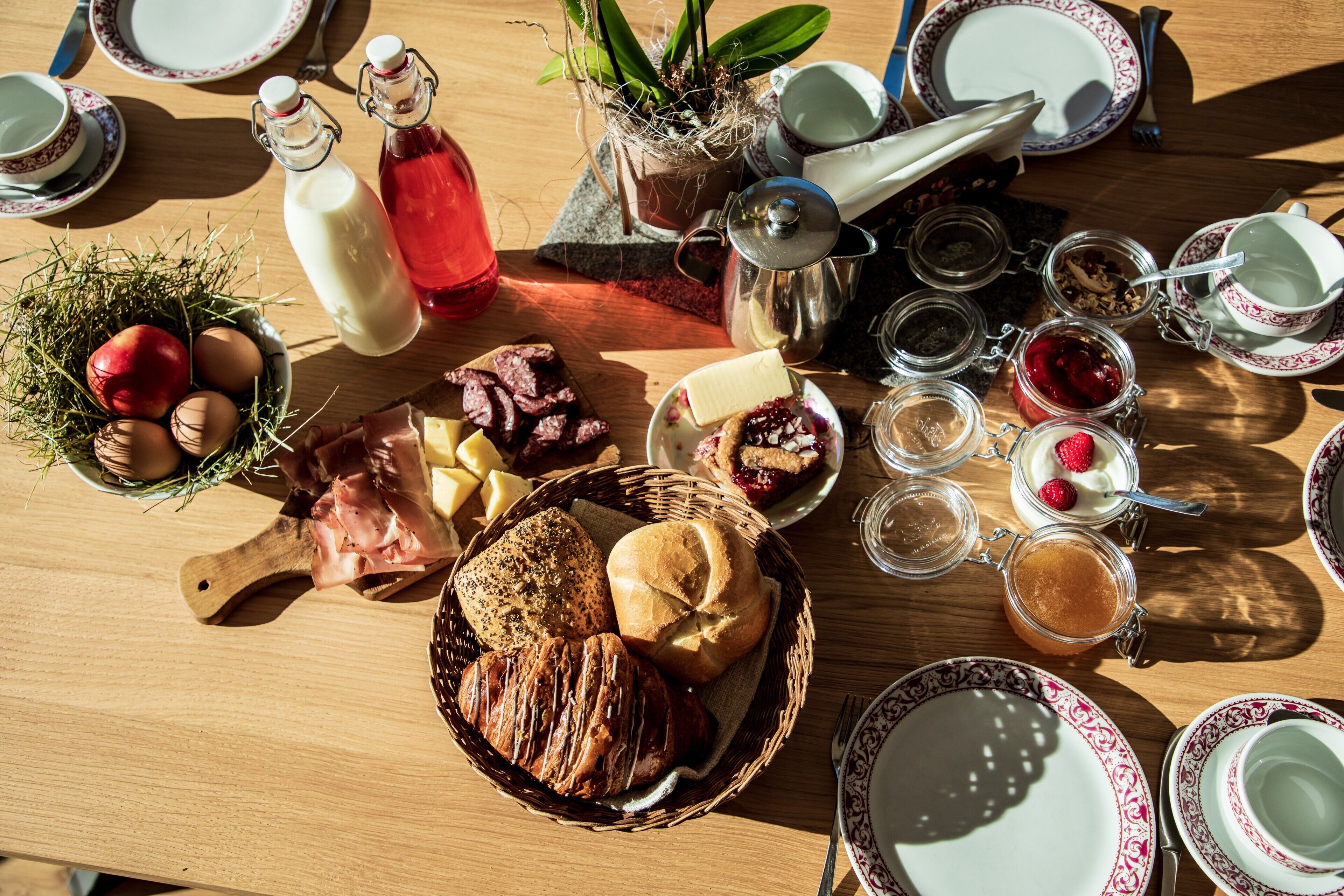 Ein Frühstückstisch mit verschiedenen Speisen, Besteck und Gläsern.