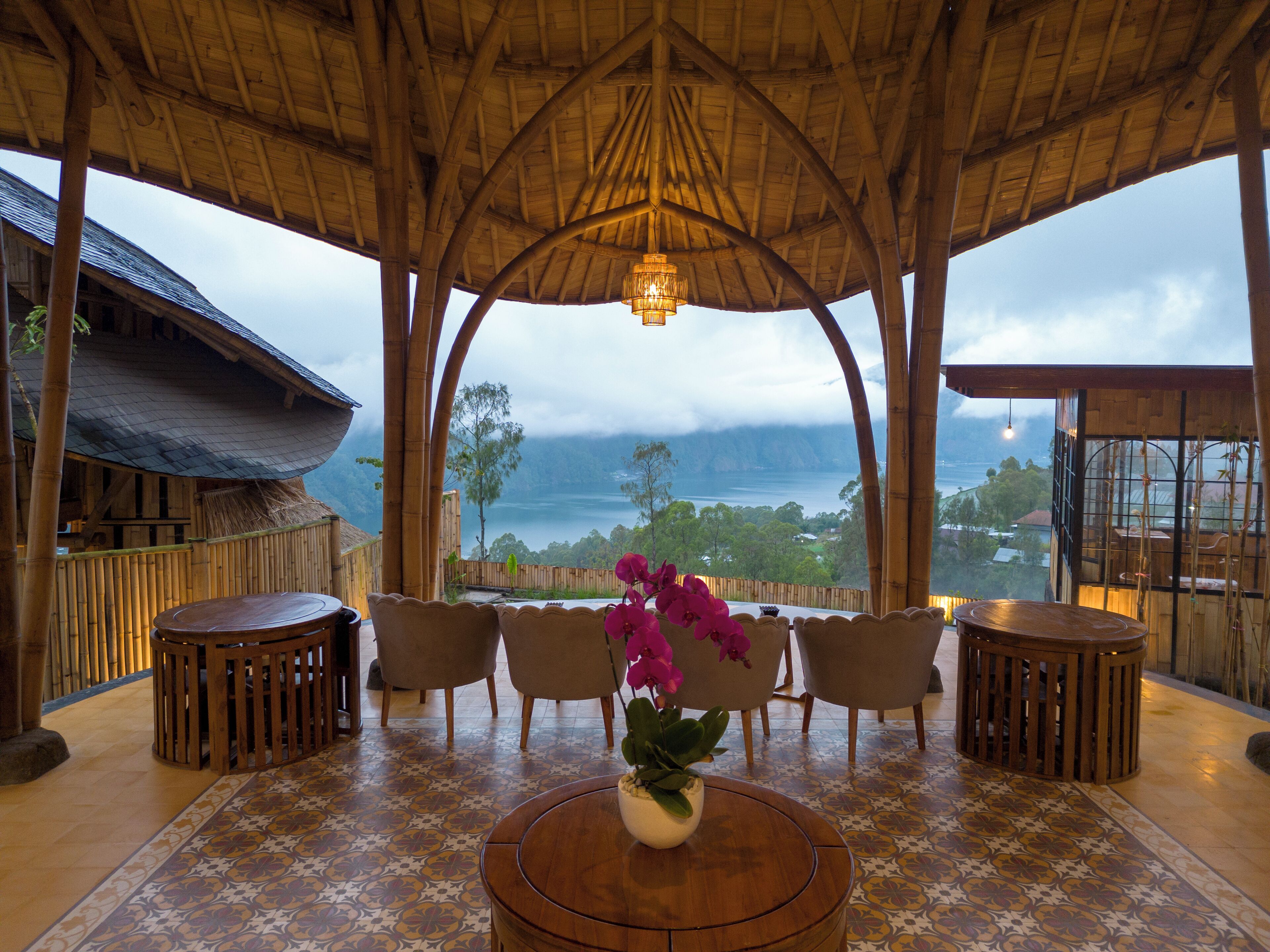A covered seating area with a view of a lake and mountains.