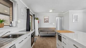 A compact kitchen with a built-in oven, a sink, and a wooden countertop.