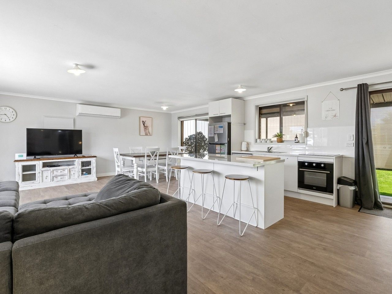 A modern apartment with a living room, kitchen, and dining area.