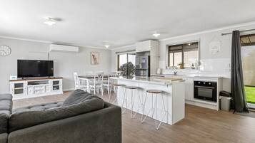 A modern apartment with a living room, kitchen, and dining area.