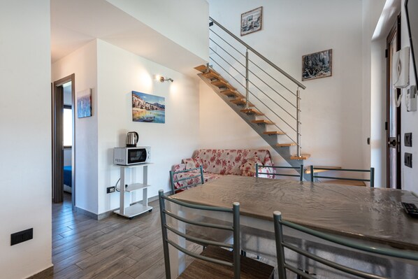 A modern interior with a dining area, a staircase, and a living space.