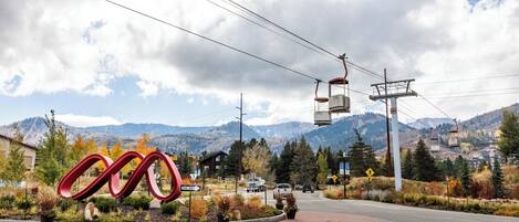 A road with a roundabout, a large red sculpture, and a mountain backdrop.