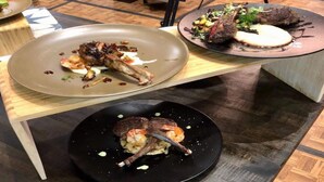 Una mesa de comedor con tres platos de comida.