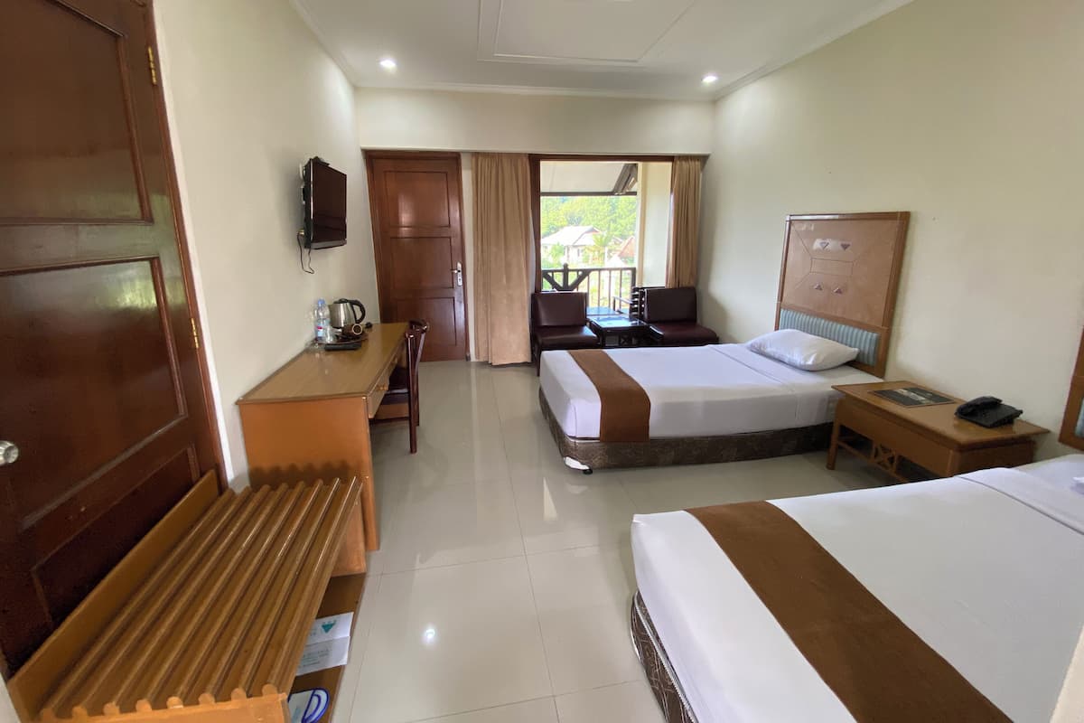 A hotel room with two beds, a desk, a chair, a TV, and a balcony with curtains.