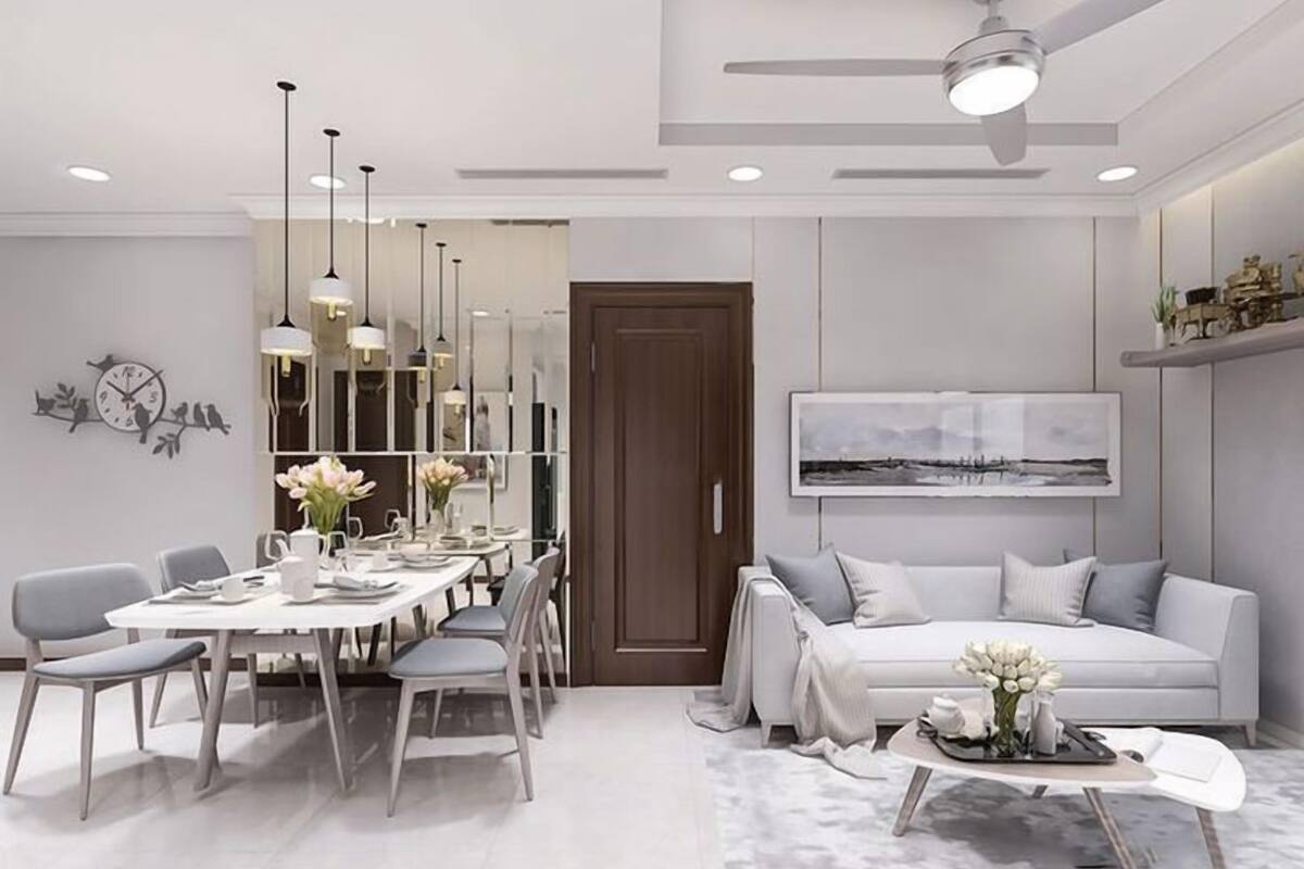 A modern living room with a dining area, a sofa, and a ceiling fan.