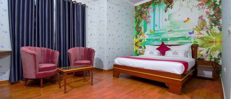 Un dormitorio con una cama de madera, dos sillones rosa, una mesita y un mural floral en la pared.