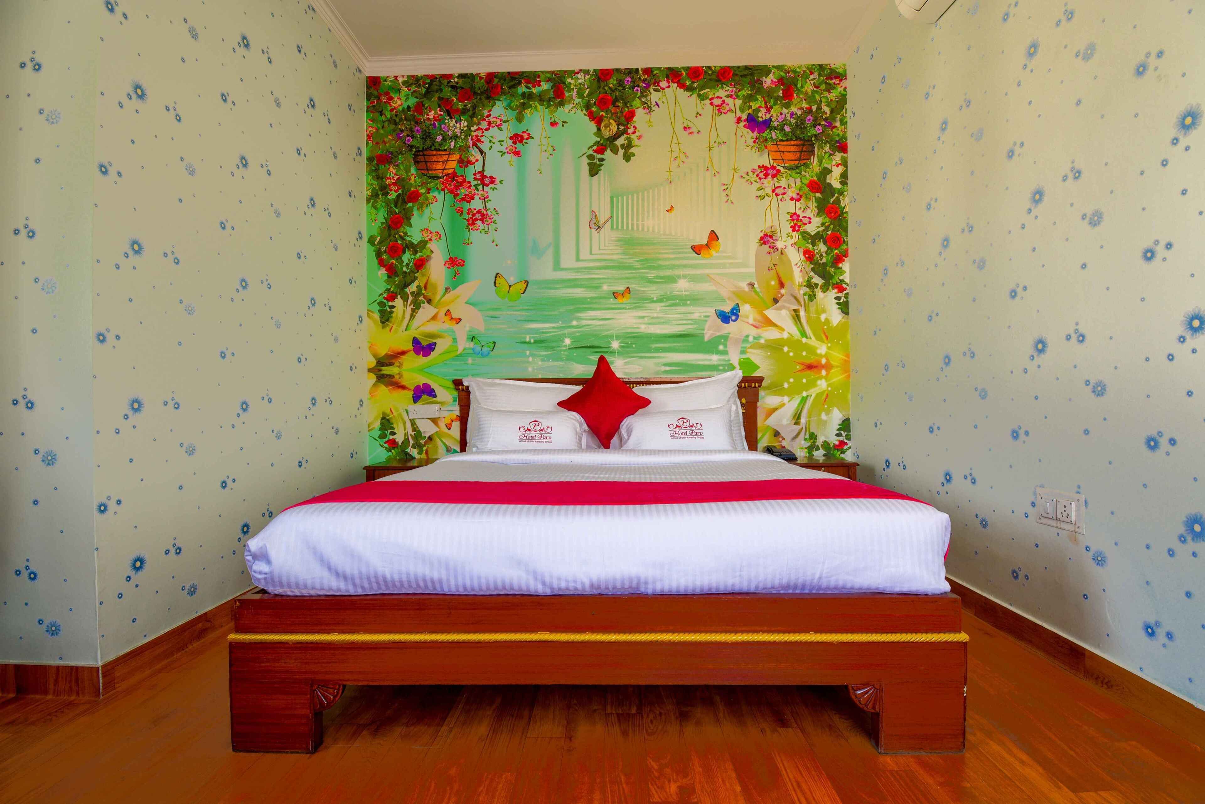 Un dormitorio con cama de madera, papel tapiz floral y un diseño de sendero verde en la pared.