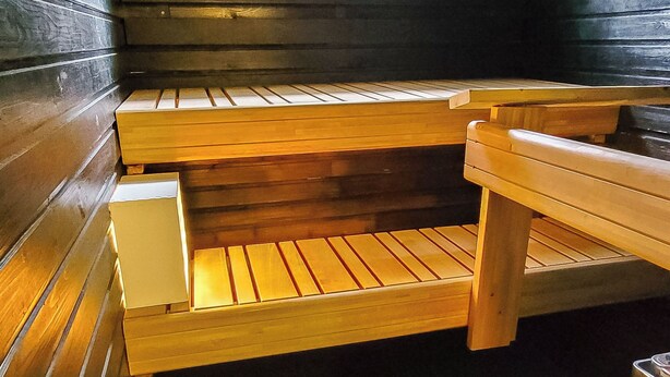 Una sauna con bancos de madera y un asiento de banco.