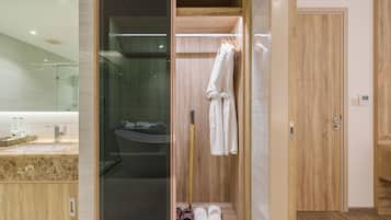 Un baño moderno con cabina de ducha de vidrio, tocador de madera y bañera empotrada.