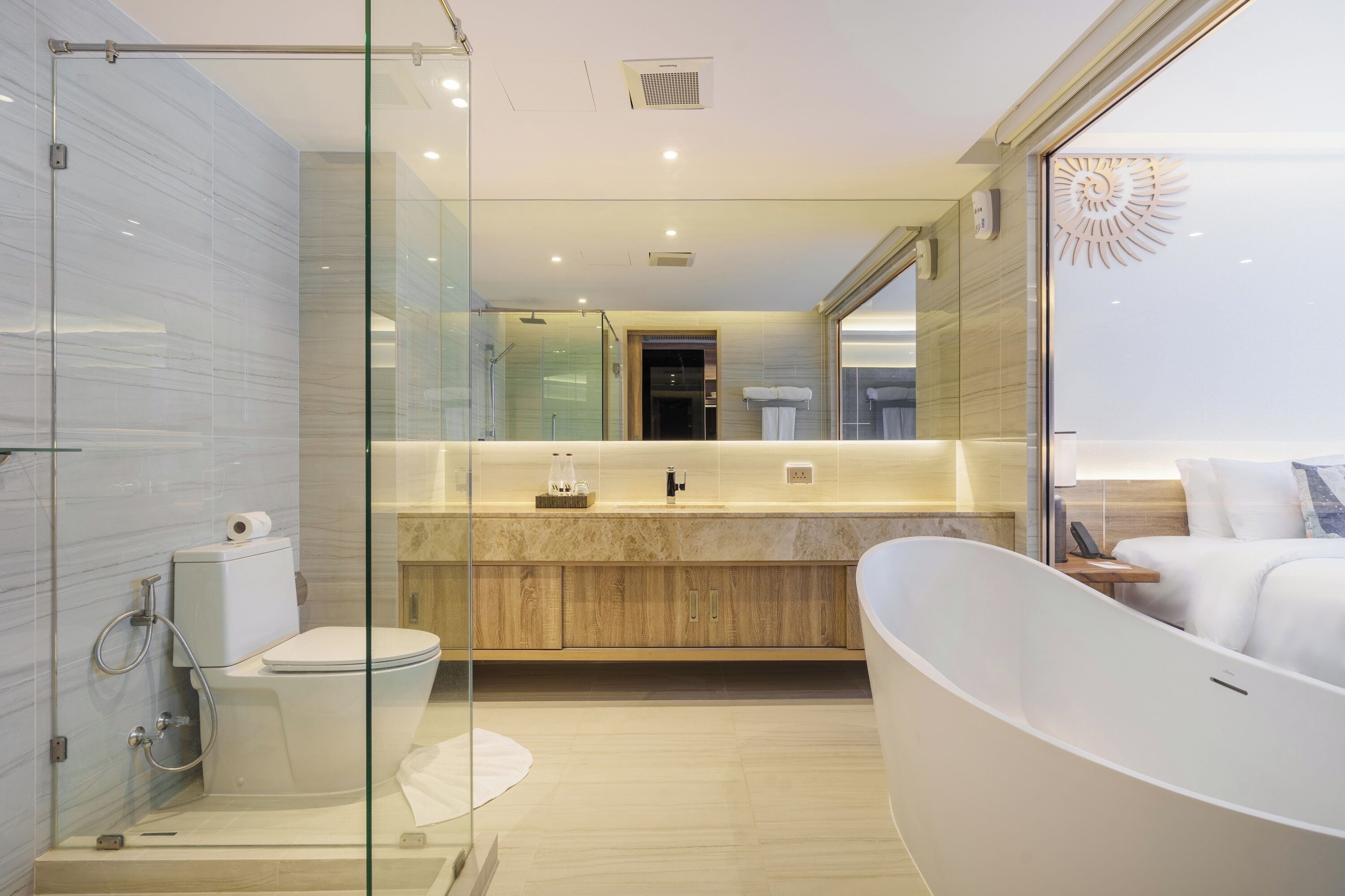 Un baño moderno con cabina de ducha de vidrio, una bañera independiente y un tocador con espejo.