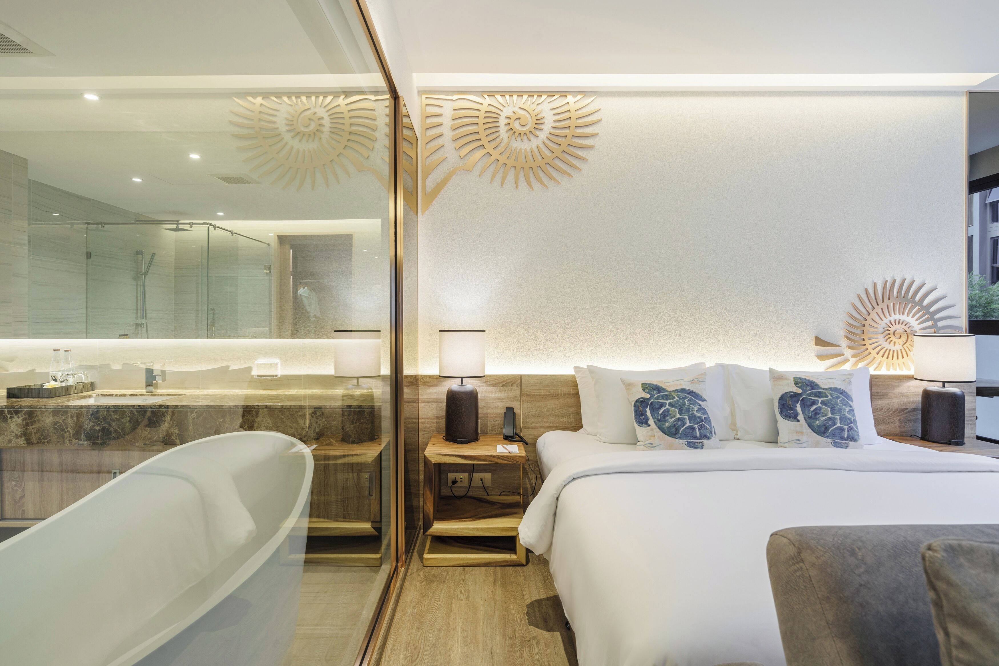 A modern hotel room with a large bed, a separate bathroom with a bathtub, and decorative wall art.