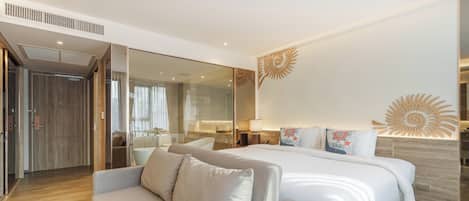 Une chambre d’hôtel moderne dotée d’un grand lit, d’un canapé, d’une cloison en verre et d’un élément décoratif mural.