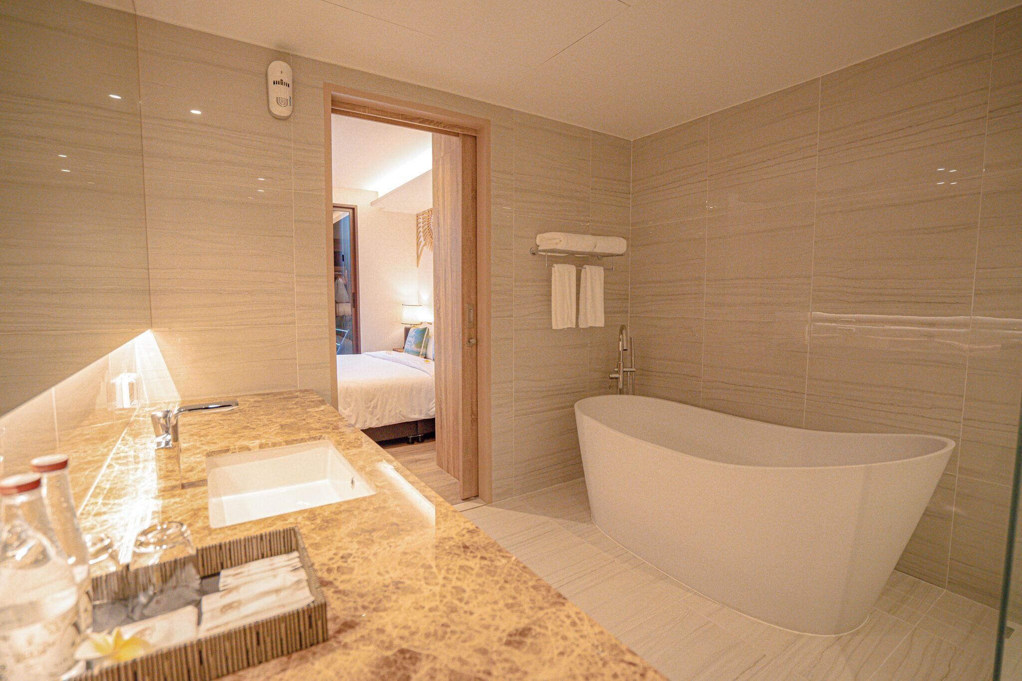 A modern bathroom with a large bathtub, a vanity with a mirror, and a shower area.