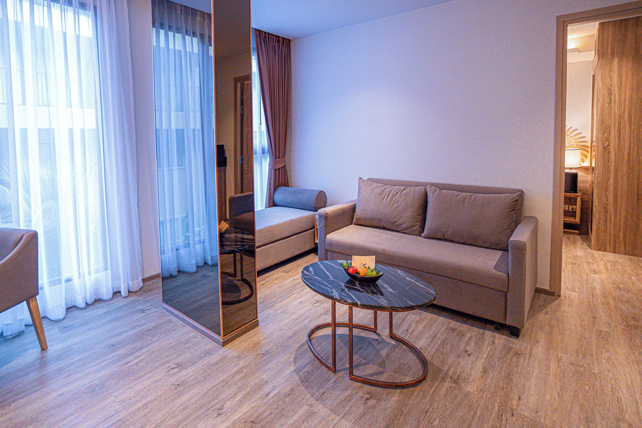 A modern living room with a sofa, a coffee table, and a mirror.