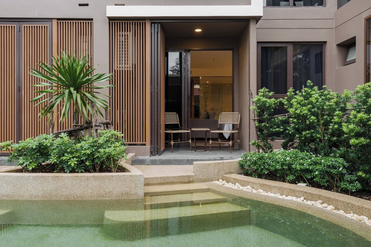 A modern building with a pool, outdoor seating, and well-maintained landscaping.