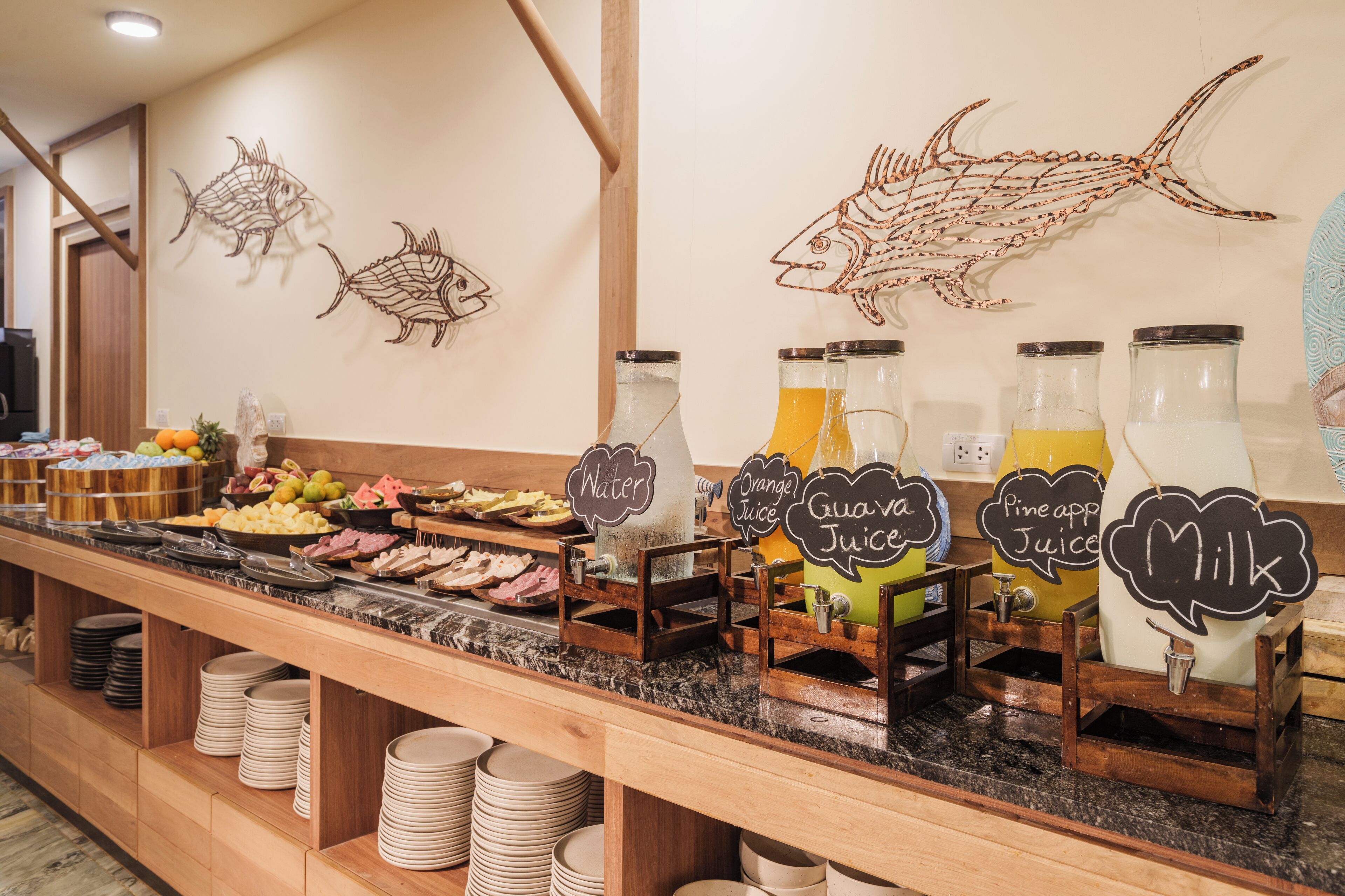 A buffet with various food items and beverage dispensers labeled with types of juices.