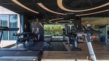 A modern gym with treadmills, dumbbells, and exercise equipment.