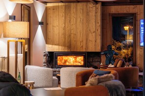 A cozy living room with a fireplace, comfortable seating, and a television. - Casa Moho Saint-François-Longchamp 1450 (Saint-François-Longchamp)