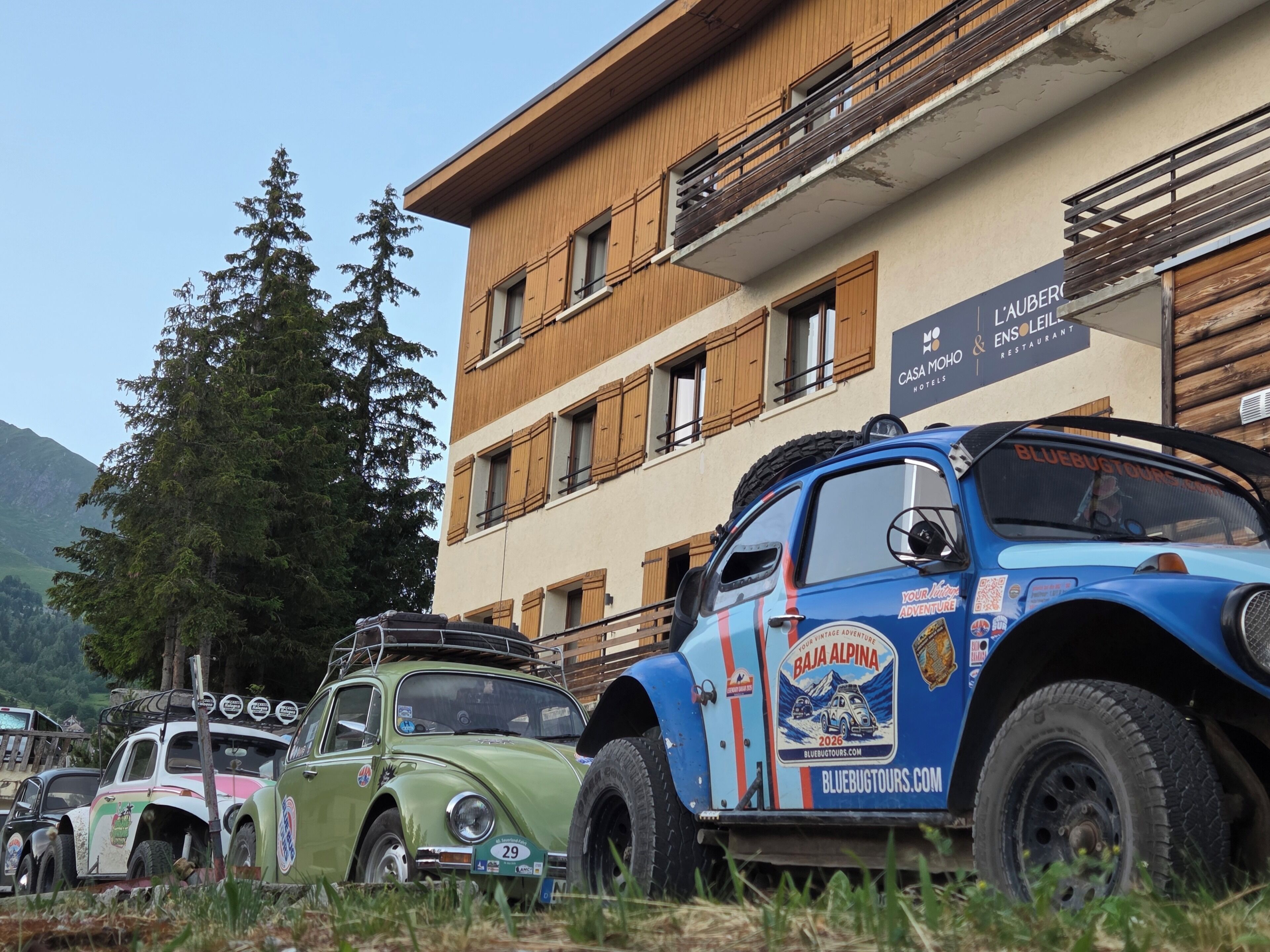 Automóviles antiguos estacionados frente a un edificio con un cartel que dice 'Casa Moro Hotels & Restaurant'.