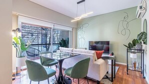Una sala de estar moderna con un sofá, sillones, una mesa de centro y un televisor.