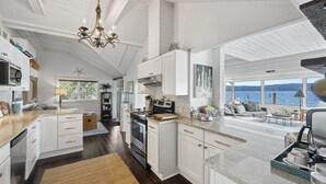 Una cocina amplia con armarios blancos, una isla grande y vistas al lago.