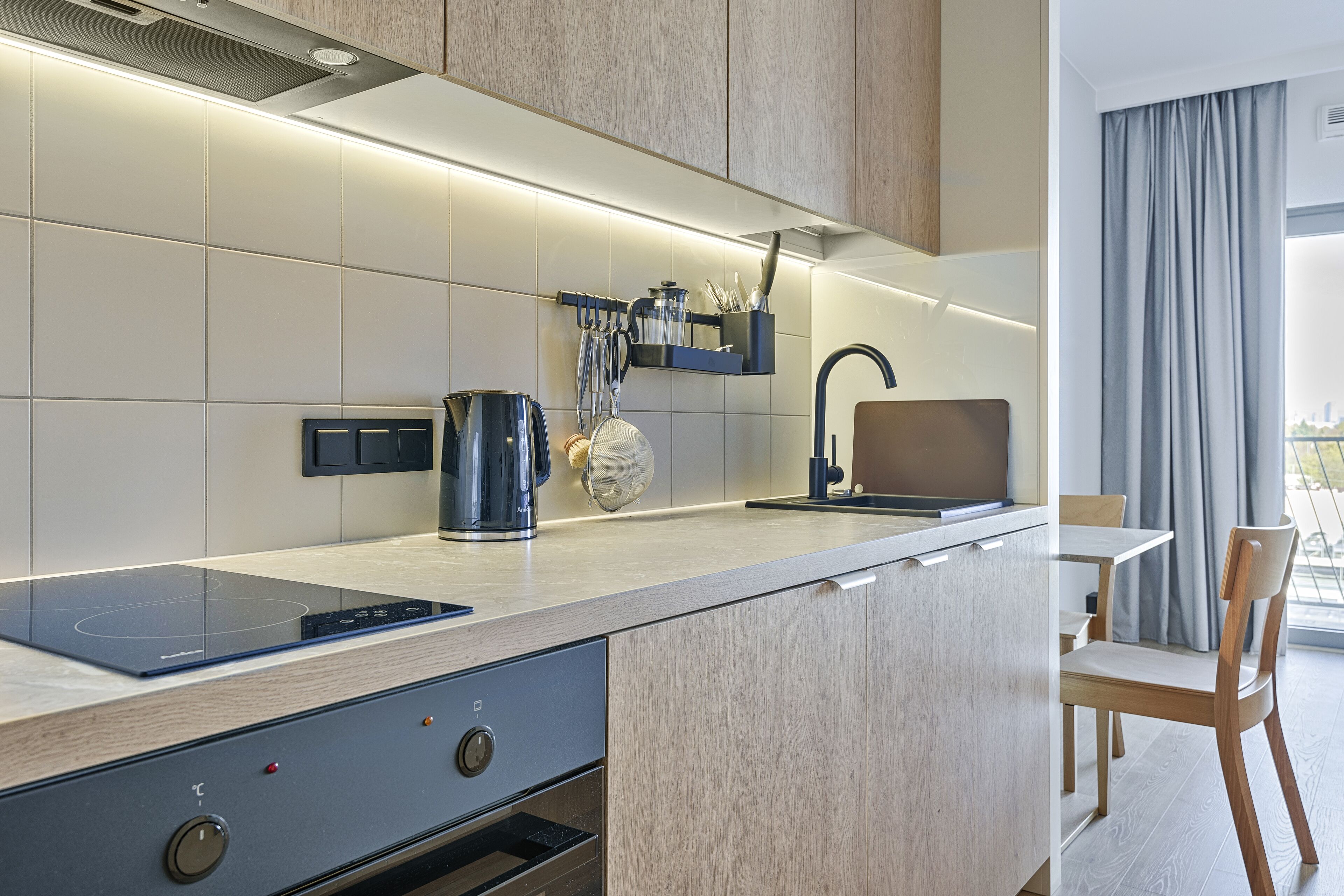 Una cocina moderna con estufa integrada, cafetera y lavaplatos.
