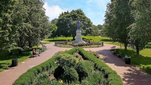 A park with a central monument, benches, and manicured gardens. - Enjoy your stay in this cozy, newly renovated condo in the heart of German Village (Columbus)