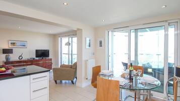 Eine moderne Küche mit Essbereich, einem Fernseher und einem Balkon mit Blick.