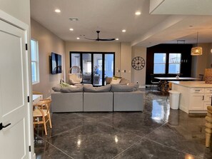 A modern kitchen with a large island, a built-in seating area, and a dining table.