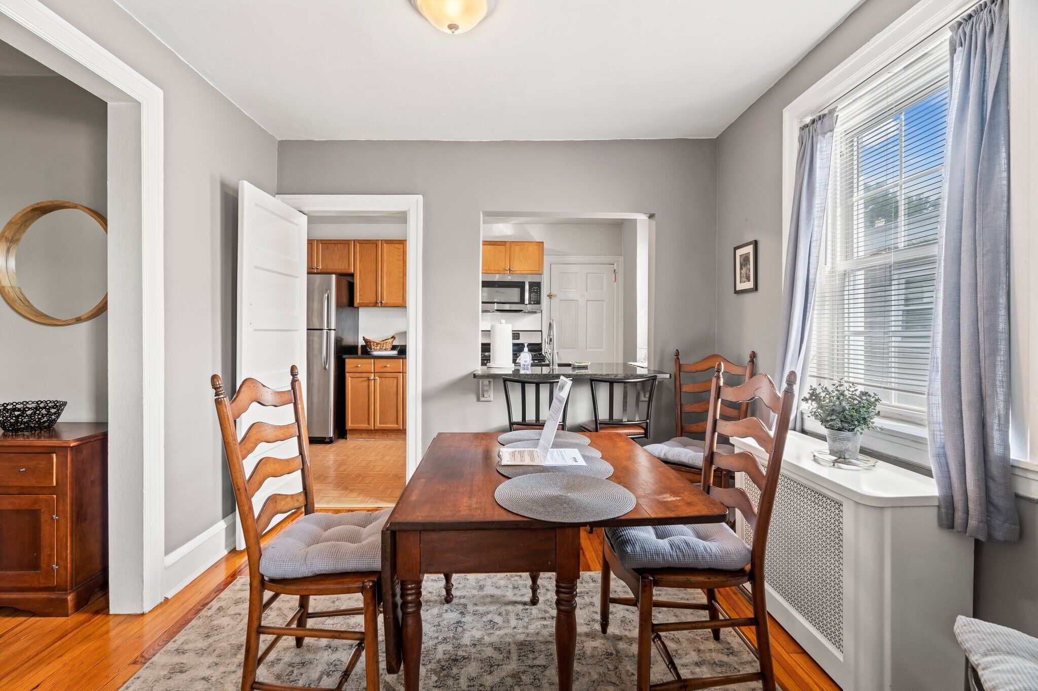 Un comedor con una mesa de madera, sillas y vista a la cocina.