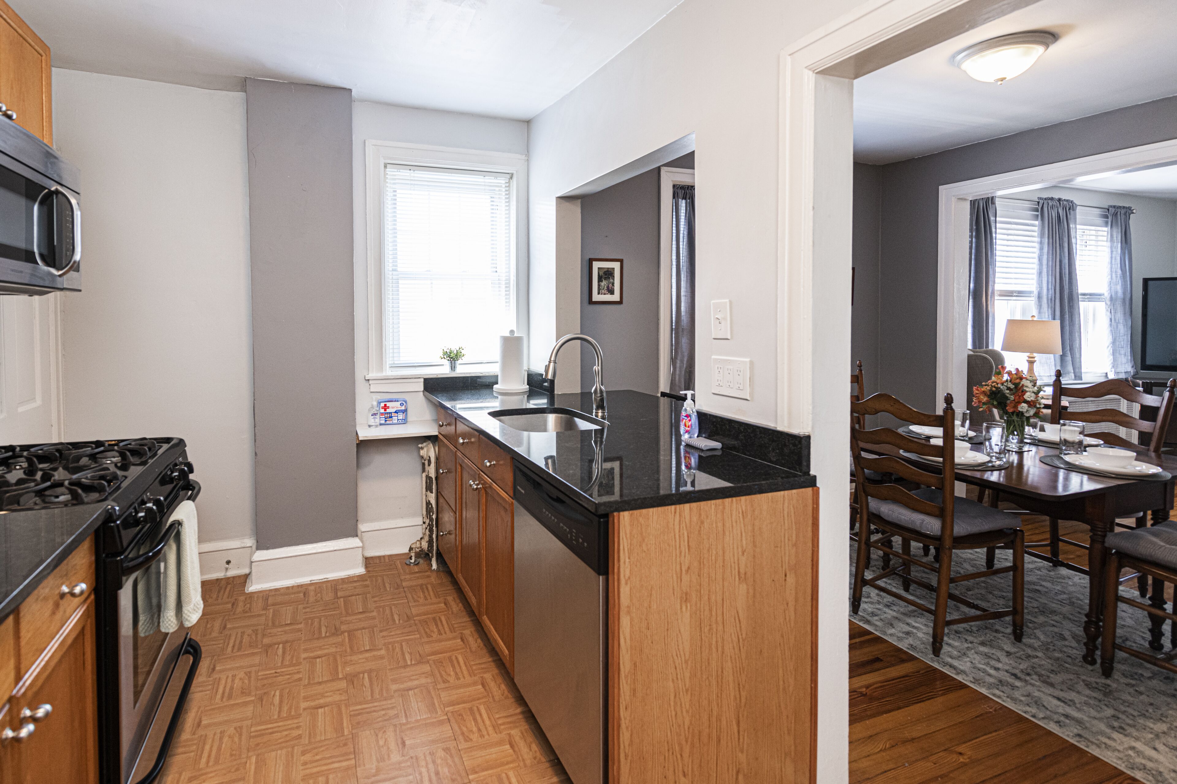A modern kitchen with a central island, wooden cabinets, and a built-in microwave.