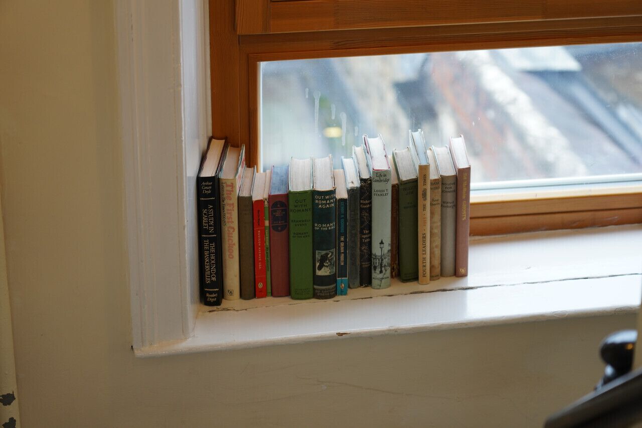 Un rebord de fenêtre orné d’une rangée de livres.