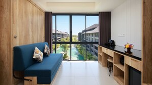 Una cocina moderna con un ventanal grande, un sofá azul con cojines y vistas a una zona residencial.